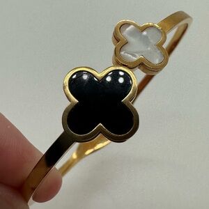 Gold tone mother of pearl and black enamel flower hinge bangle